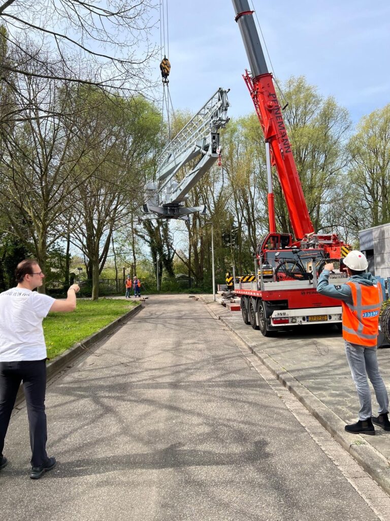 Een hijskraan van Bouwma die een object langzaam op de grond zet
